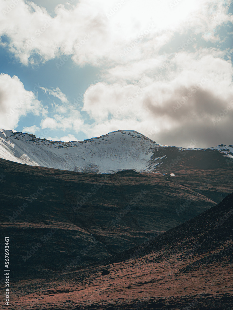 Breathtaking view of a snow-capped mountain on a sunny day with clouds in the sky in Iceland