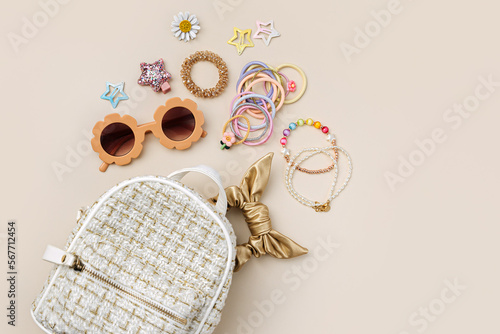 Fashion backpack with sunglasses, kids jewelry and hair accessories. Baby girl stuff and  accessory. photo