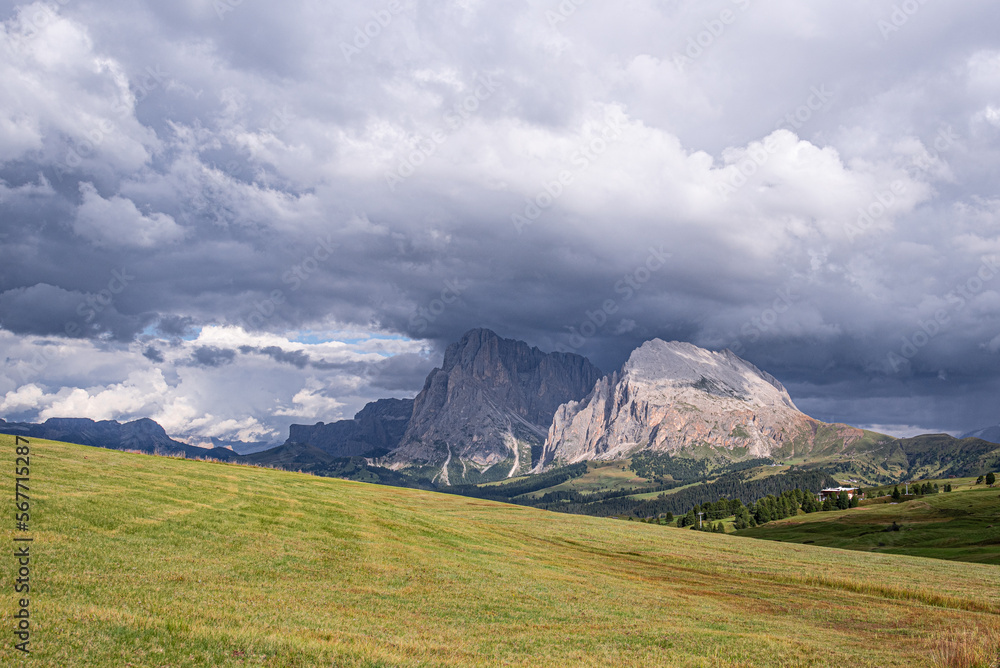 Heavy cloud lying on the top of Sassolungo and Sassopiatto mountains  as seen from Alp di Siusi high mountain plateau , Seiser Alm, Dolomites, Trentino, Alto Adige, Italy