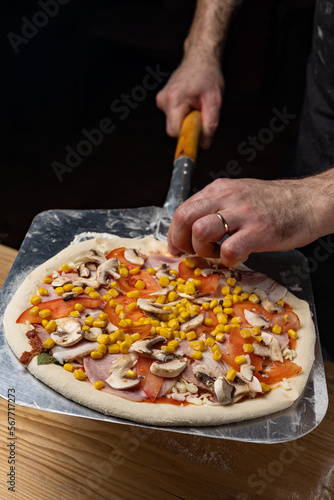 Fototapeta Naklejka Na Ścianę i Meble -  the chef prepares delicious pizza in the restaurant. Close-up
