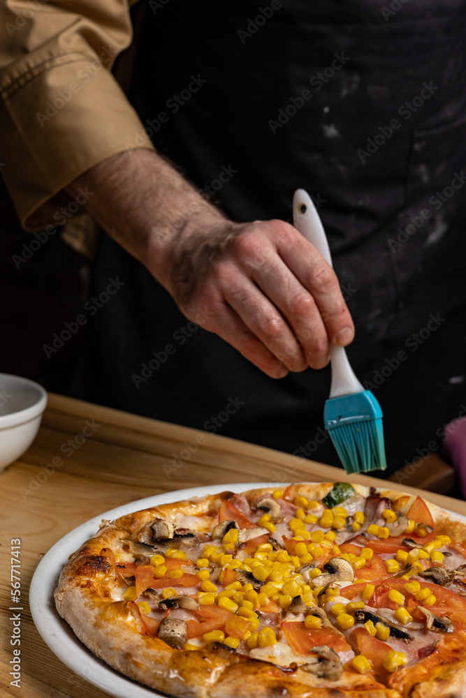 the chef prepares delicious pizza in the restaurant. Close-up
