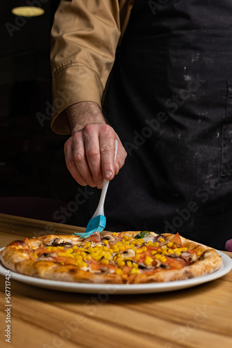 the chef prepares delicious pizza in the restaurant. Close-up 