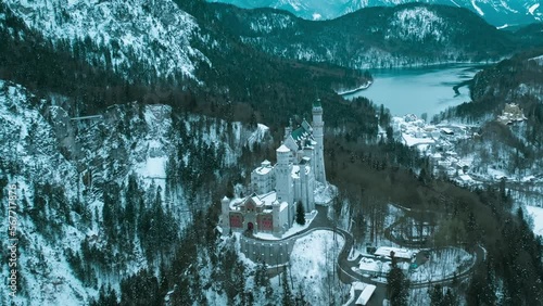 Aerial drone view Neuschwanstein castle on Alps background in vicinity of Munich, Bavaria, Germany, Europe. Winter landscape with castle and lake in snowy mountains covered with spruce forest. photo