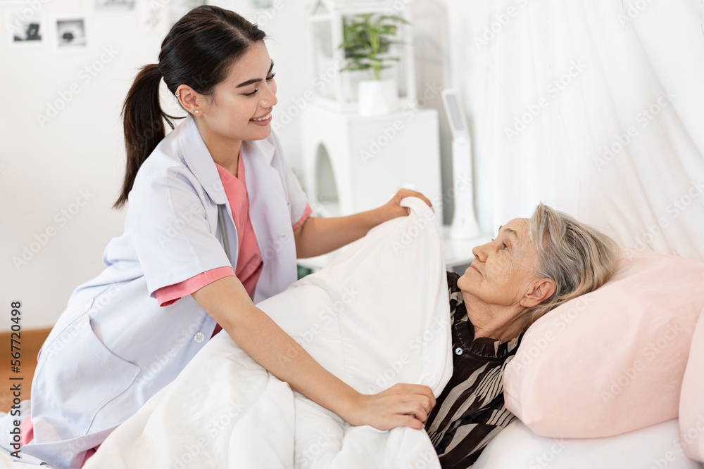 Fototapeta premium Woman caucasian doctor take care caucasian older woman of cover her with a blanket in bedroom at home 