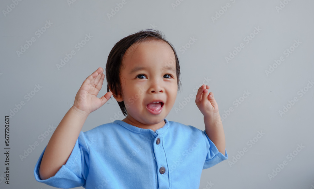 cute little asian boy smiling to the camera, on grey background. cute little asian boy smiling to the camera, on grey background.