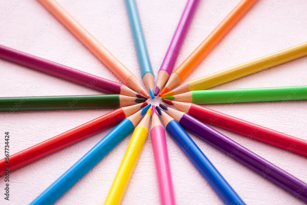 Colorful pencils in circle composition on pink background, art education concept card Colorful pencils in circle composition on pink background, art education concept card