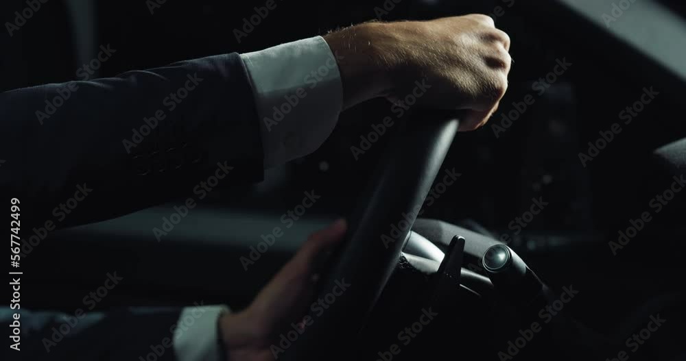 Side Close Up of the Hands of a Man Grabbing the Steering Wheel Firmly. A Businessman in Trying Out a Car Before Buying it in a Dealership. Concept of Car Advertisement, Sales, Manufacturing Side Close Up of the Hands of a Man Grabbing the Steering Wheel Firmly. A Businessman in Trying Out a Car Before Buying it in a Dealership. Concept of Car Advertisement, Sales, Manufacturing