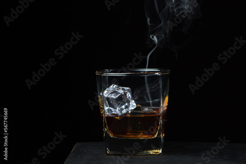 Glass of whiskey with ice on a black background. alcoholic drink