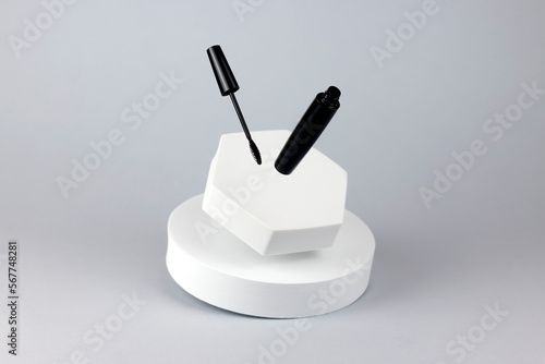 Flying mascara with geometric podiums on white background. cosmetic levitation concept. cosmetic product mockup.