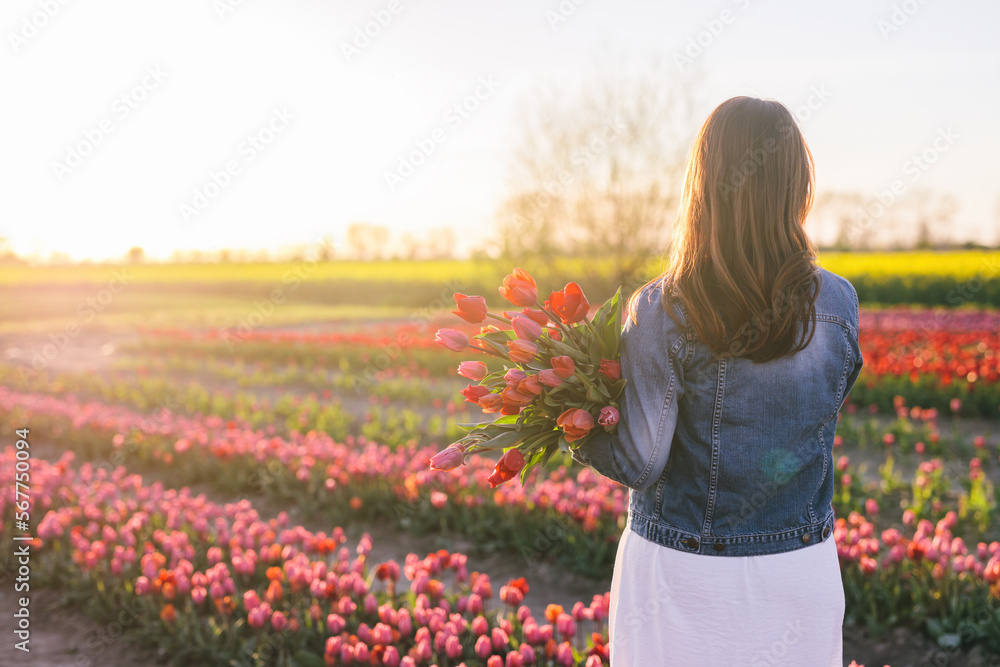 Woman with flowers bouquet on tulip field in spring. Woman with flowers bouquet on tulip field in spring.