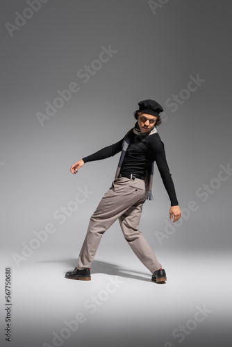 full length of african american man in black beret and fashionable casual attire posing on grey background © LIGHTFIELD STUDIOS
