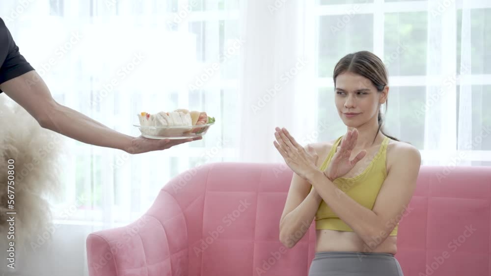 Young woman in workout clothes refuses to eat unhealthy food. Young woman in workout clothes refuses to eat unhealthy food.