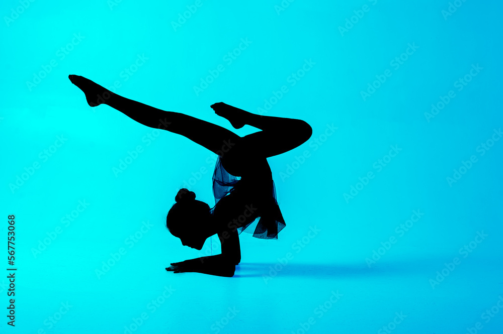Silhouette of a gymnast who performs exercises with a ball. Blue background
