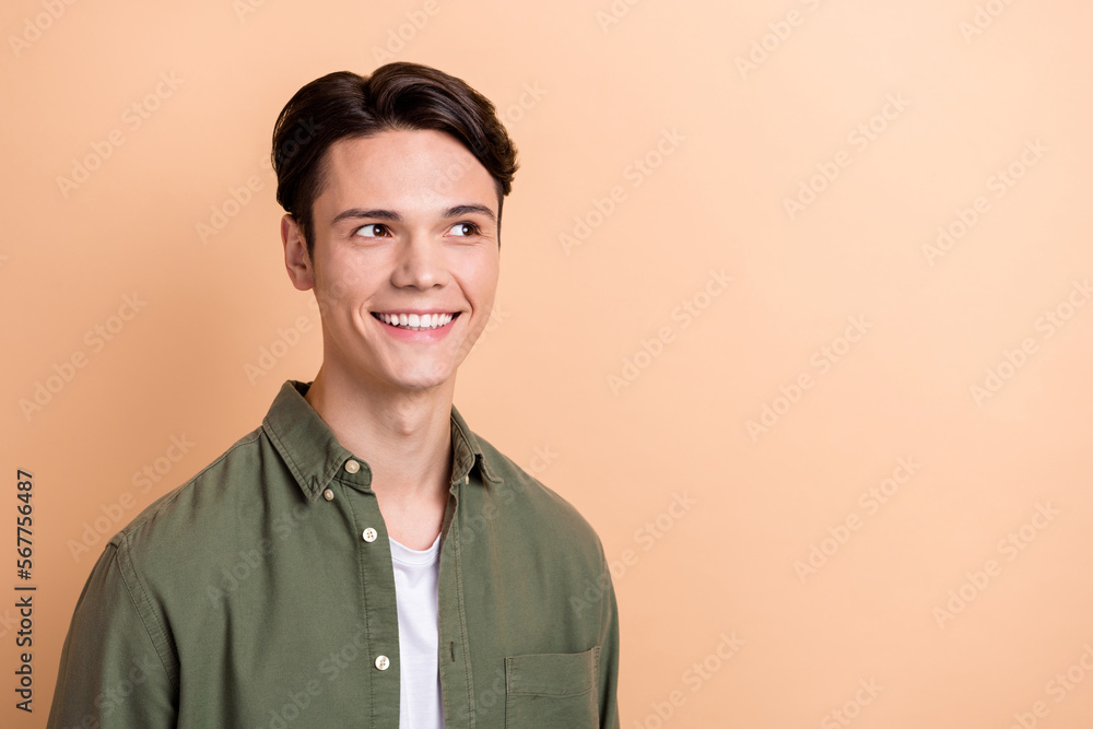 Photo of cheerful glad person beaming smile look empty space news isolated on beige color background Photo of cheerful glad person beaming smile look empty space news isolated on beige color background
