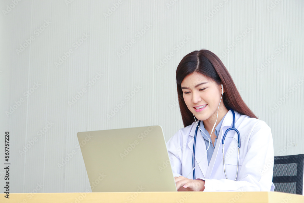 Beautiful Asian female doctor using a laptop computer working in the office. Online doctor concept. copy space Beautiful Asian female doctor using a laptop computer working in the office. Online doctor concept. copy space