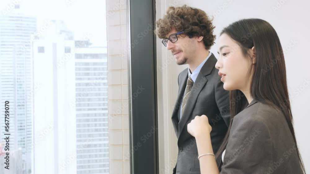 Caucasian businessman with asian businesswoman discussing development strategy for office project in modern building. Caucasian businessman with asian businesswoman discussing development strategy for office project in modern building.