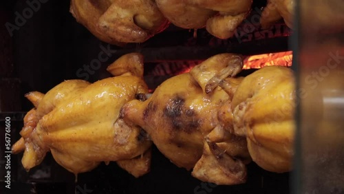 Whole roast chicken turning on spit. Street food barbecue. Cooking chicken barbecue.