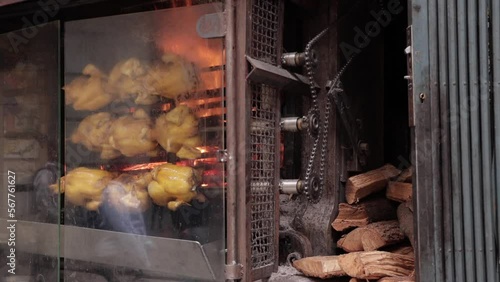Whole roast chicken turning on spit. Street food barbecue. Cooking chicken barbecue.