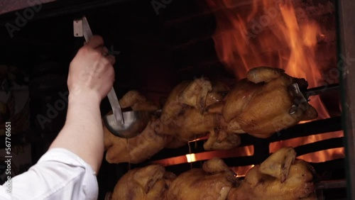 Whole roast chicken turning on spit. Street food barbecue. Cooking chicken barbecue.