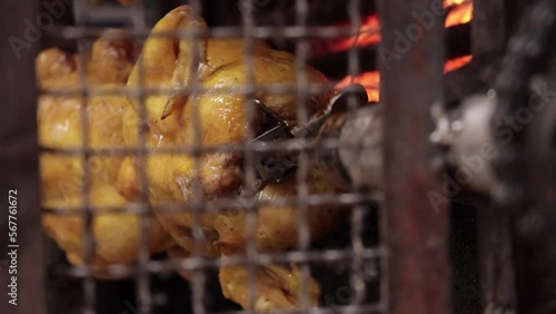 Whole roast chicken turning on spit. Street food barbecue. Cooking chicken barbecue.