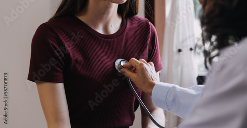 Homecare nursing service and elderly people cardiology healthcare. Close up of young hispanic female doctor nurse check mature caucasian man patient heartbeat using stethoscope during visit