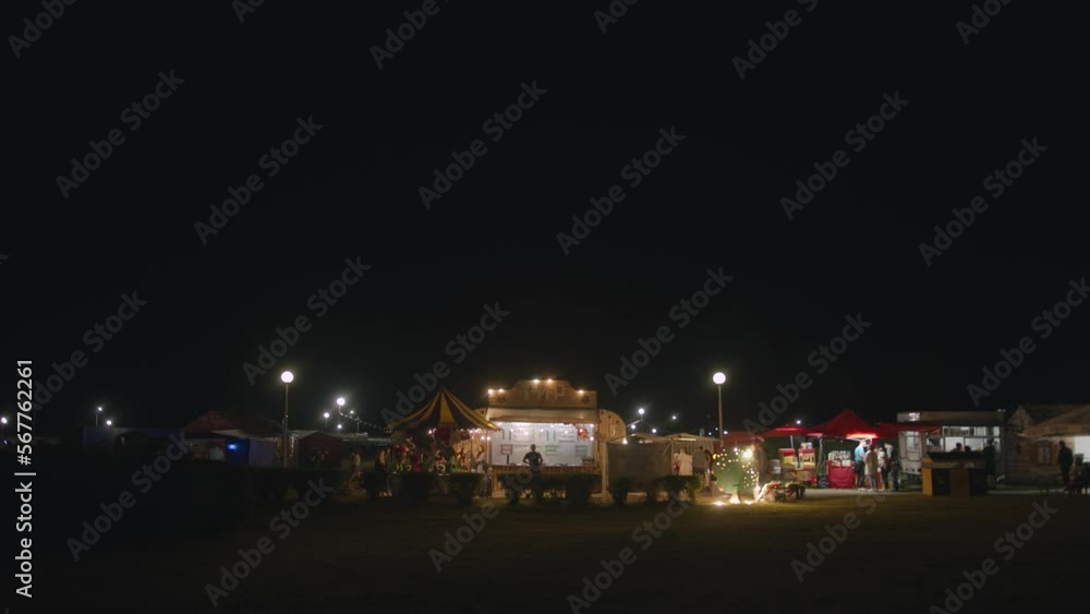 Rows of illuminated tents with drinks and food at a city festival in the park. Slow motion Rows of illuminated tents with drinks and food at a city festival in the park. Slow motion