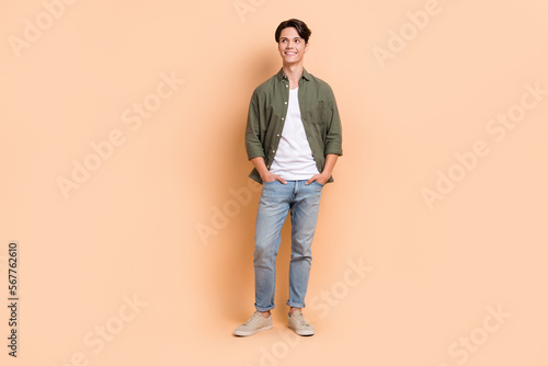 Full body size photo of young cheerful guy dreaming looking empty space advertisement promo new brand sale isolated on beige color background