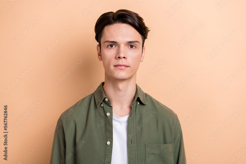 Photo of calm focused concentrated young man nice new haircut isolated on beige color background Photo of calm focused concentrated young man nice new haircut isolated on beige color background