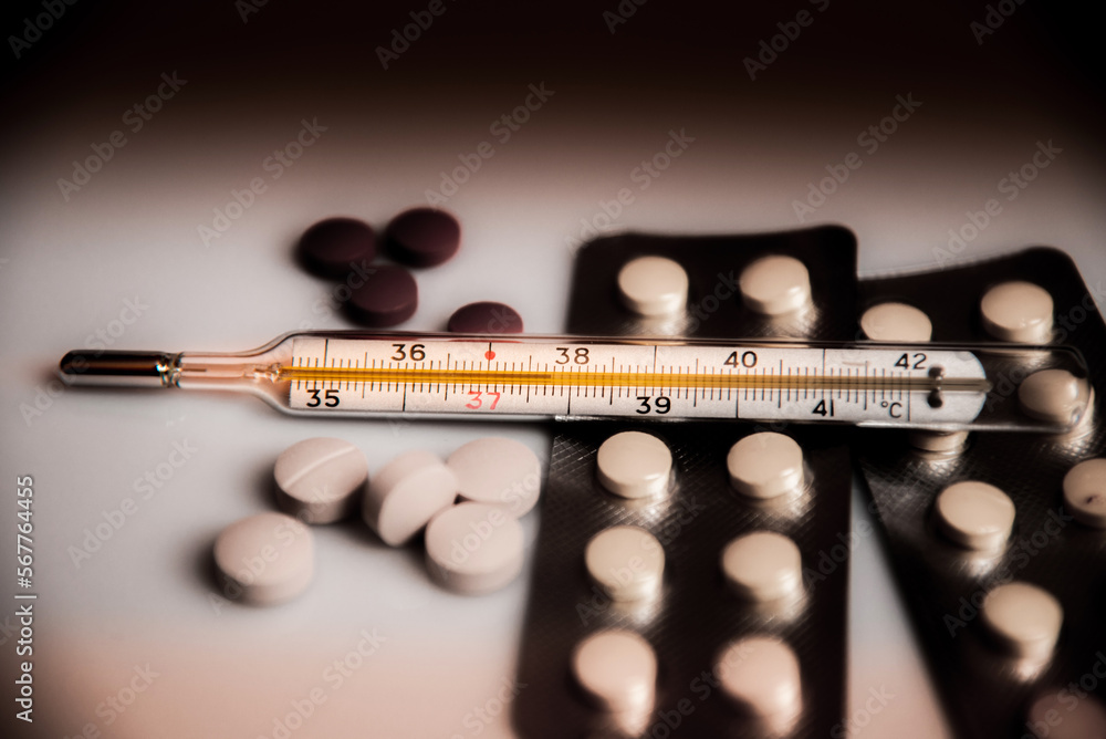 Abstract dark pessimistic image of a thermometer with high temperature and medication (Сovid - concept).