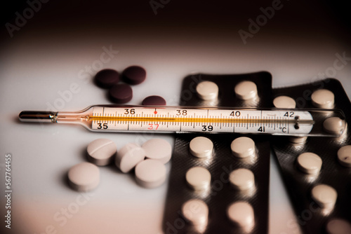 Obraz na płótnie Abstract dark pessimistic image of a thermometer with high temperature and medication (Сovid - concept). w salonie