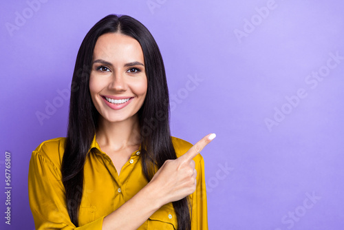 Photo of cheerful lovely lady wear trendy clothes arm demonstrate empty space positive feedback isolated on purple color background