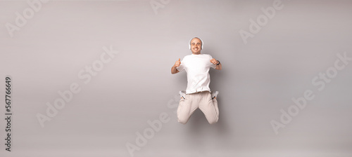 Photography Banner size studio shot of a young man wearing headphones and jumping high