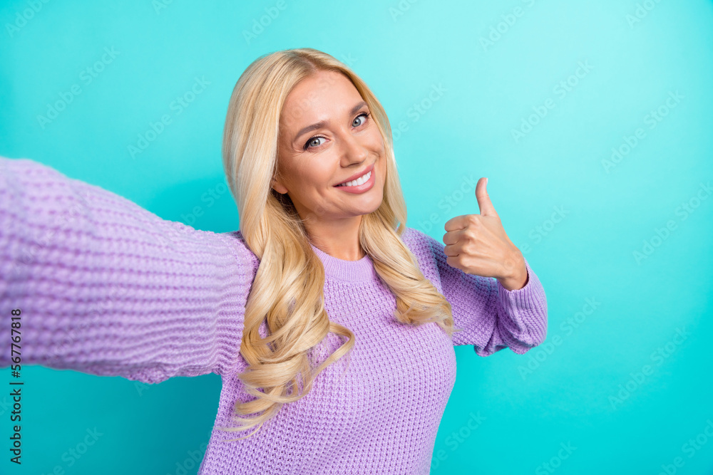 Fototapeta premium Selfie closeup photo portrait of middle age expert blogger lady smile thumb up like her influencer job isolated on aquamarine color background