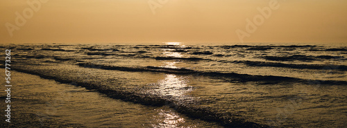 Golden sunset in the wavy Baltic Sea, Golden Hour. Golden reflection of sunlight in the water.