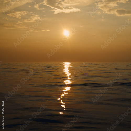 Golden sunset in the calm Baltic Sea, clear sky. Golden Hour. Golden reflection of sunlight in the water.