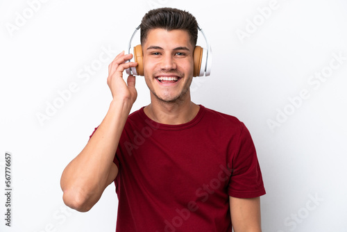 Young caucasian man isolated on white background listening music