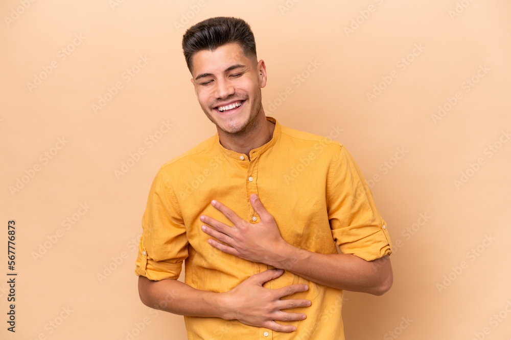 Young caucasian man isolated on beige background smiling a lot Young caucasian man isolated on beige background smiling a lot