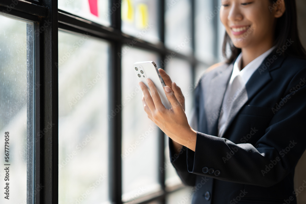 Young asian businesswoman beautiful charming smiling and talking on the mobile phone in the office. Haiving a conversation with her client.