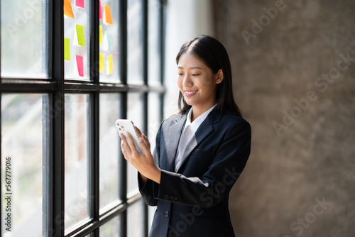 Young asian businesswoman beautiful charming smiling and talking on the mobile phone in the office. Haiving a conversation with her client. © PaeGAG