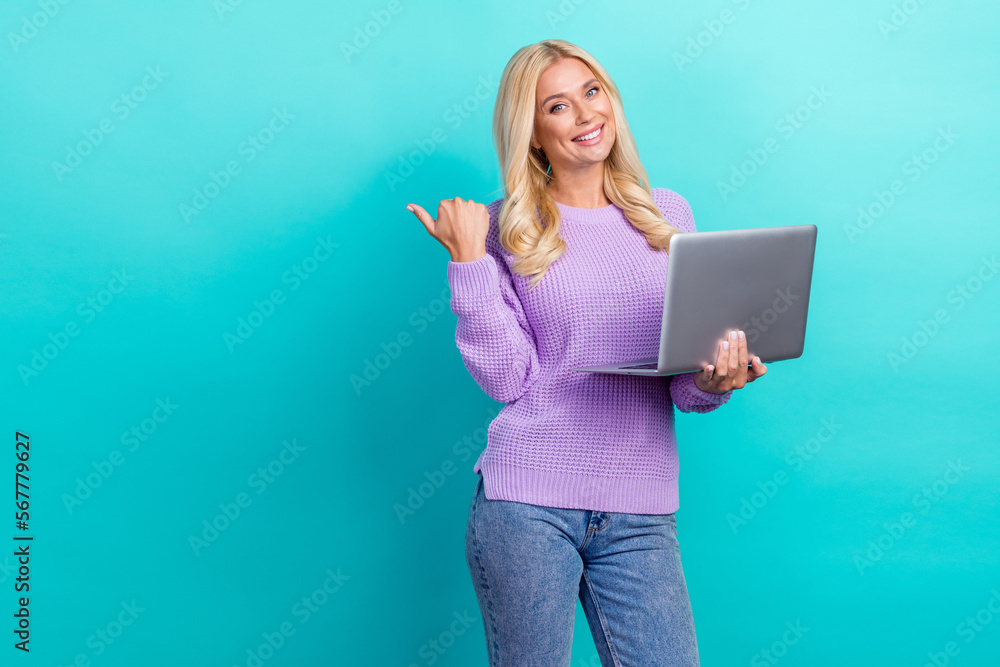 Photo of charming positive person toothy smile use netbook direct finger empty space isolated on emerald color background Photo of charming positive person toothy smile use netbook direct finger empty space isolated on emerald color background
