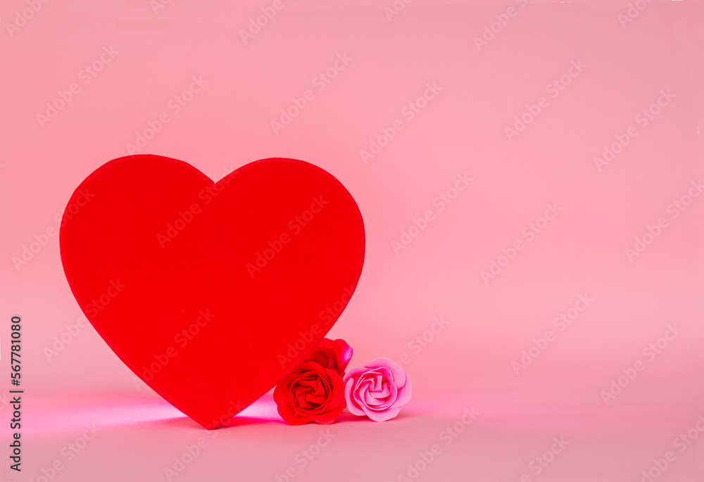 Simple copy space Valentines day red heart with three roses of different shades, set against a calm, romantic pink background. February 14th, love and romance.