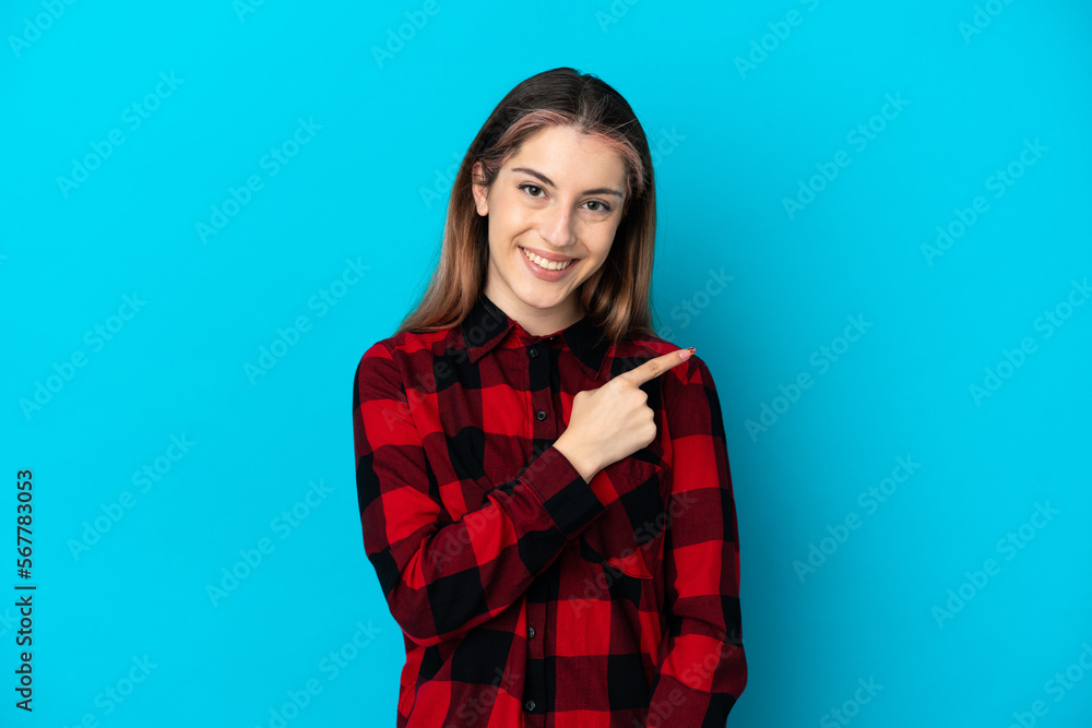 Young caucasian woman isolated on blue background pointing to the side to present a product Young caucasian woman isolated on blue background pointing to the side to present a product