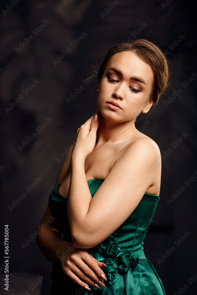 A girl in a green dress on a dark background