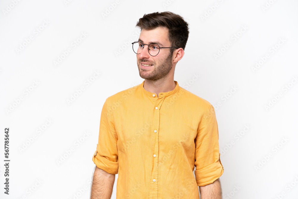 Fototapeta premium Young caucasian man isolated on white background looking to the side and smiling