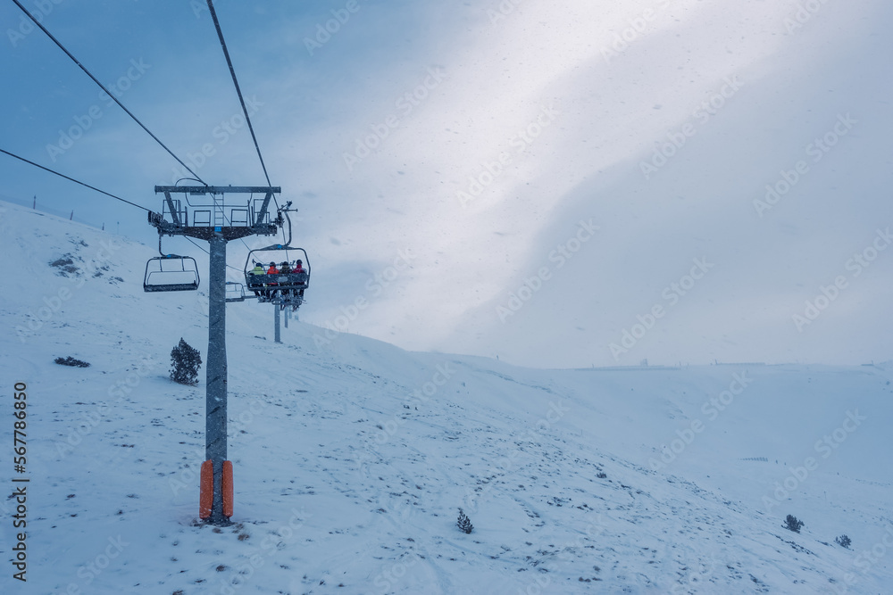 Chairlift that climbs the high mountain of the Pyrenees on a cloudy and snowy day with fog in Andorra, Grandvalira. Chairlift that climbs the high mountain of the Pyrenees on a cloudy and snowy day with fog in Andorra, Grandvalira.
