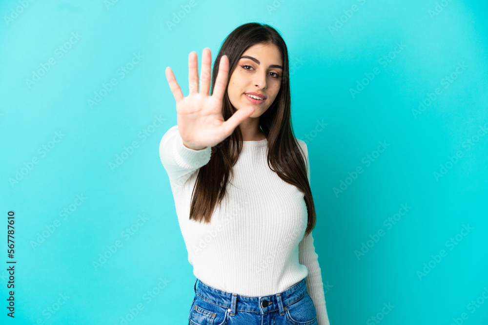 Young caucasian woman isolated on blue background counting five with fingers Young caucasian woman isolated on blue background counting five with fingers