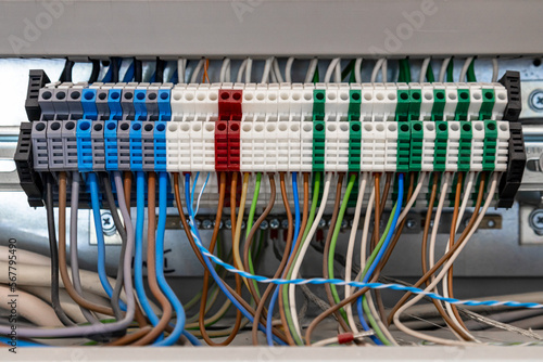 Electrical cabinet with multi-colored electric wires connected to automatic machines, close-up