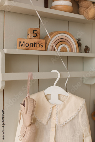 Close-up of child's clothing hanging on a coathanger with children's toys on shelves