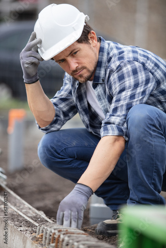 tradesman problem solving on outdoor construction site