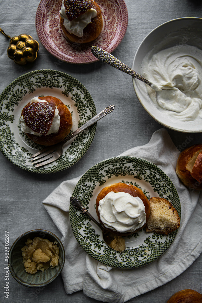 Homemade semlor buns with frangipane and whipped cream on vintage plates. Homemade semlor buns with frangipane and whipped cream on vintage plates.